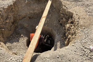 Deep holes dug, filled with special mix, and compacted as filled to provide strong support for building - see man in hole for scale.